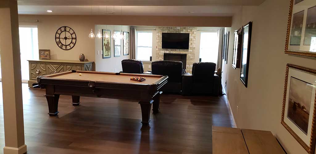 Finished basement accent wall with fireplace & tv.